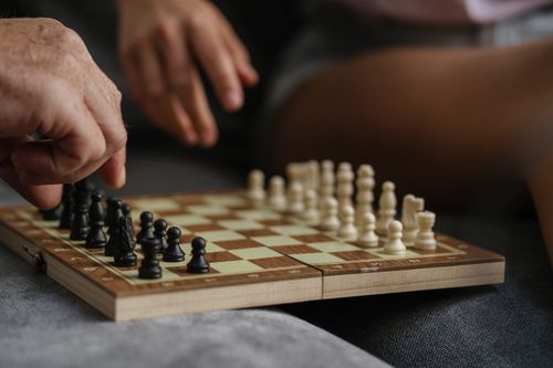 Free Close-up of two people engaged in a strategic chess match, emphasizing hands and pieces. Stock Photo