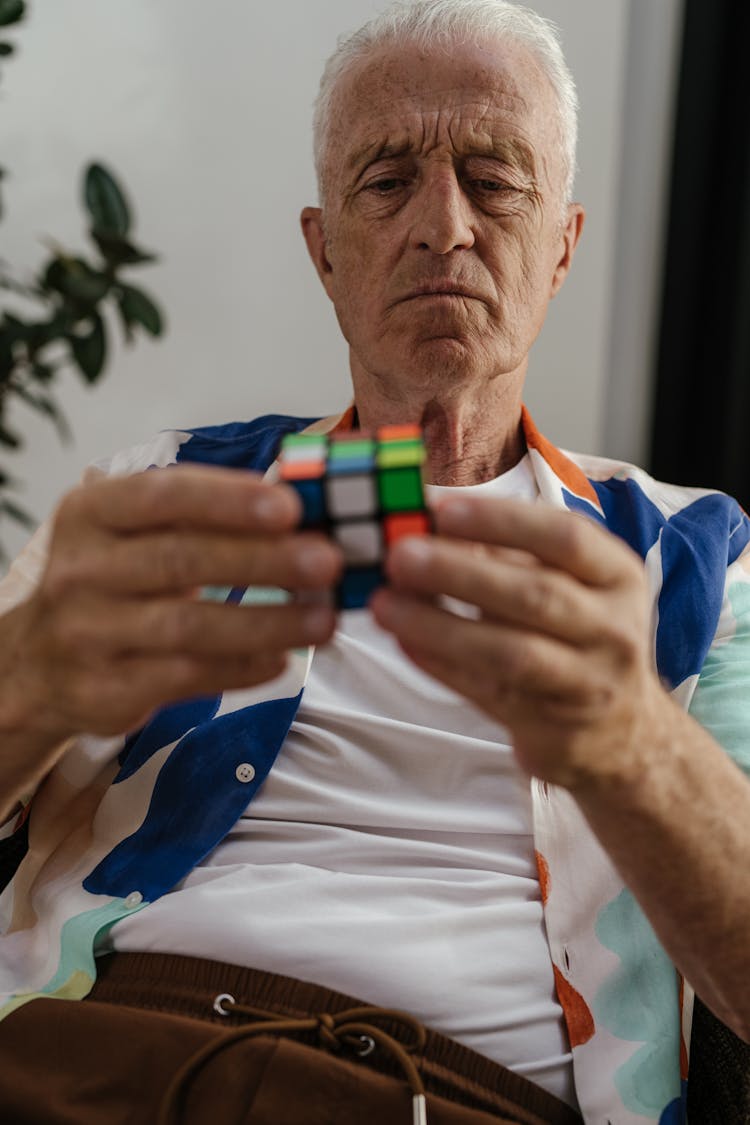 Elderly Man Solving A Rubik's Cube 