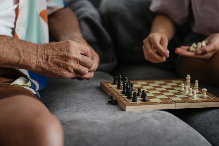 People Playing Chess While Sitting On The Couch