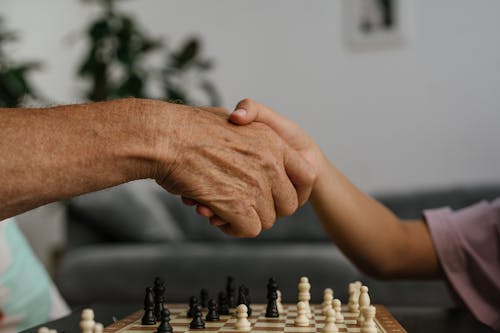 Person Shaking Hands to Elderly Man