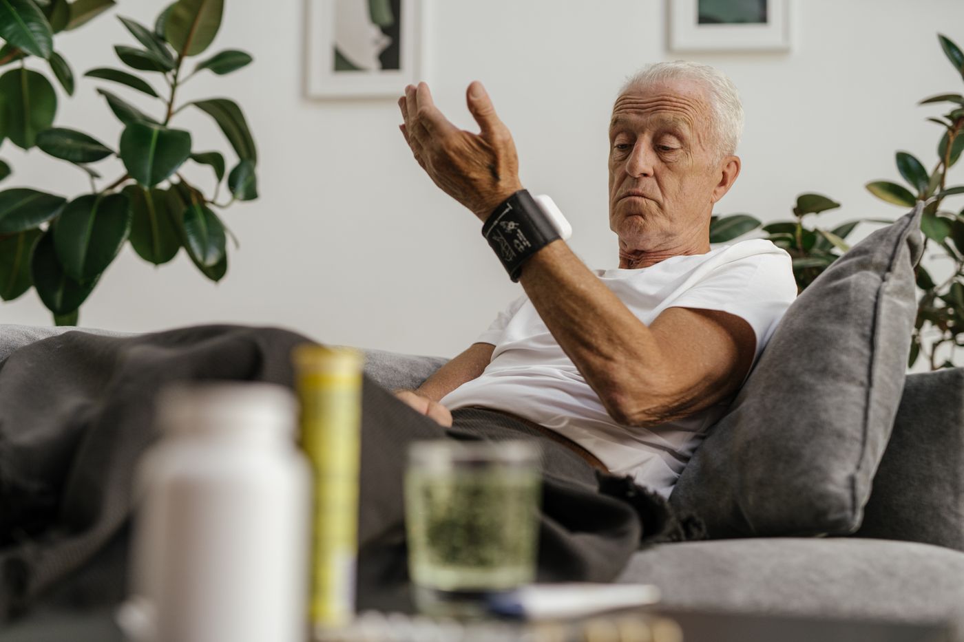Older man checking his blood pressure at home for hypertension monitoring