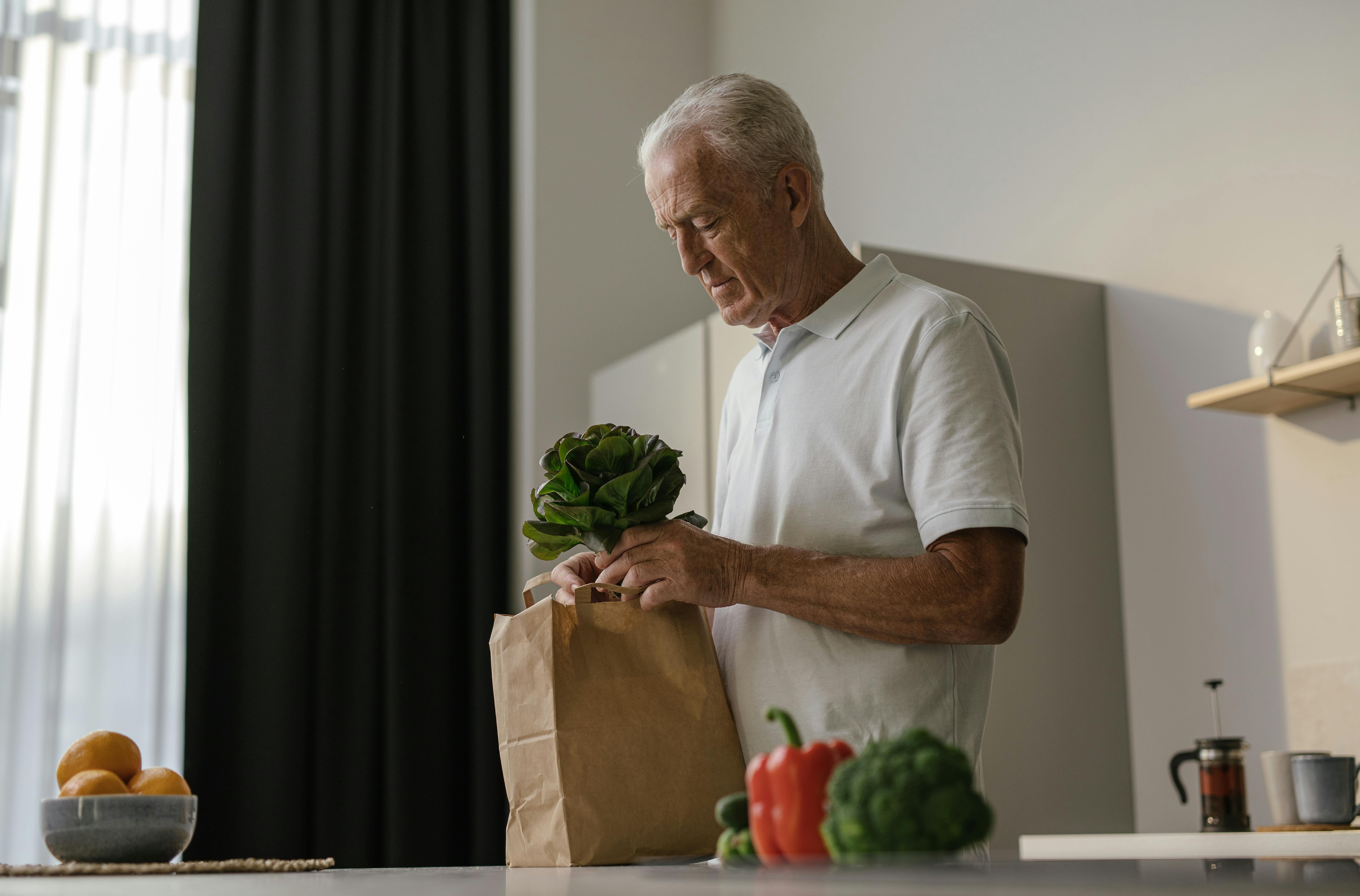 man in white polo shirt holding a fresh vegetable