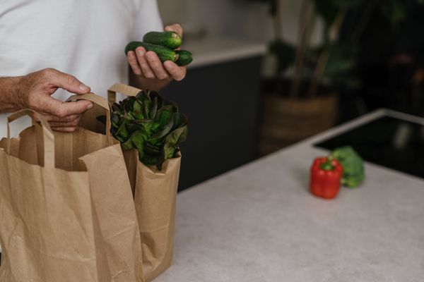 Fresh vegetables being packed into paper grocery bags — photo by SHVETS production on Pexels