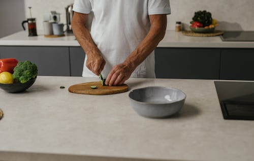 Free Person in White Shirt Slicing a Cucumber Stock Photo