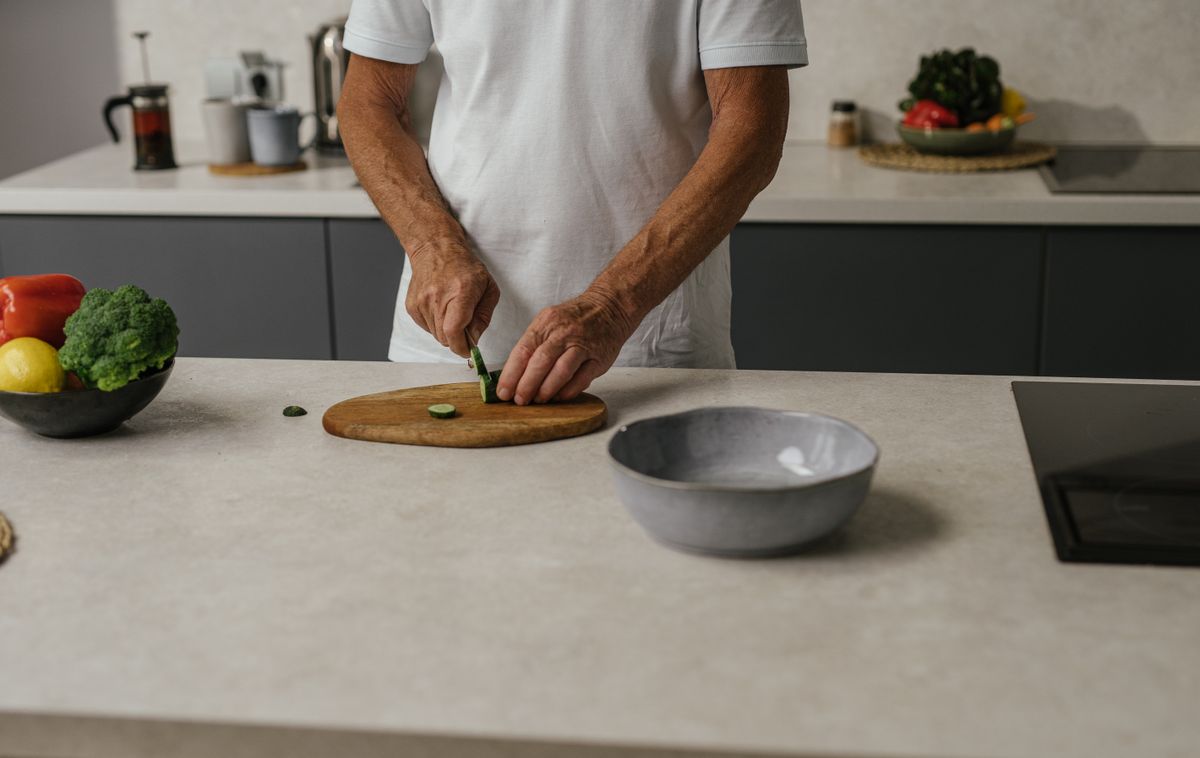 Older man confidently preparing vegetables in his kitchen