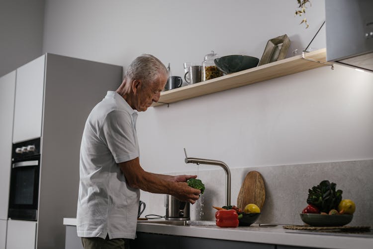 Man Washing A Vegetable On The Sink