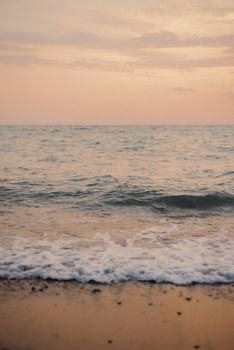 Serene beach view with gentle waves at sunset, perfect for relaxation themes.