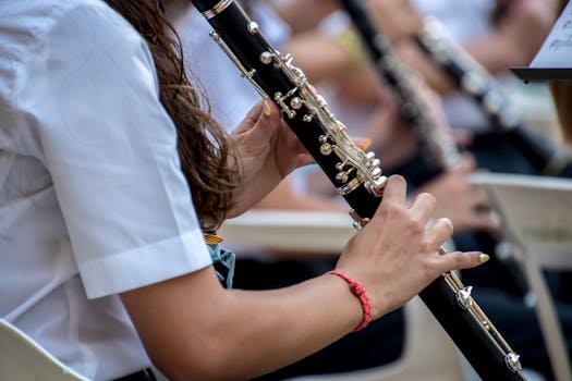 Close-up of a musician playing a clarinet during an outdoor performance. Focus on the instrument.