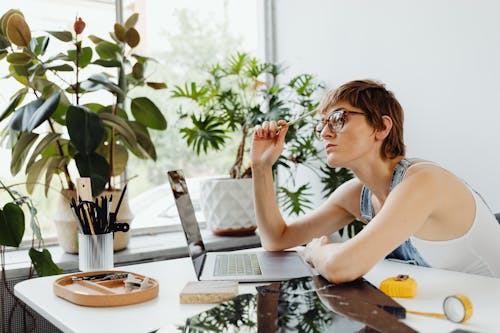 Woman Thinking in Front of a Laptop