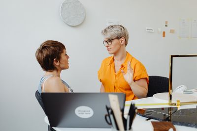 Two colleagues reviewing books together — photo by kaboompics.com on Pexels