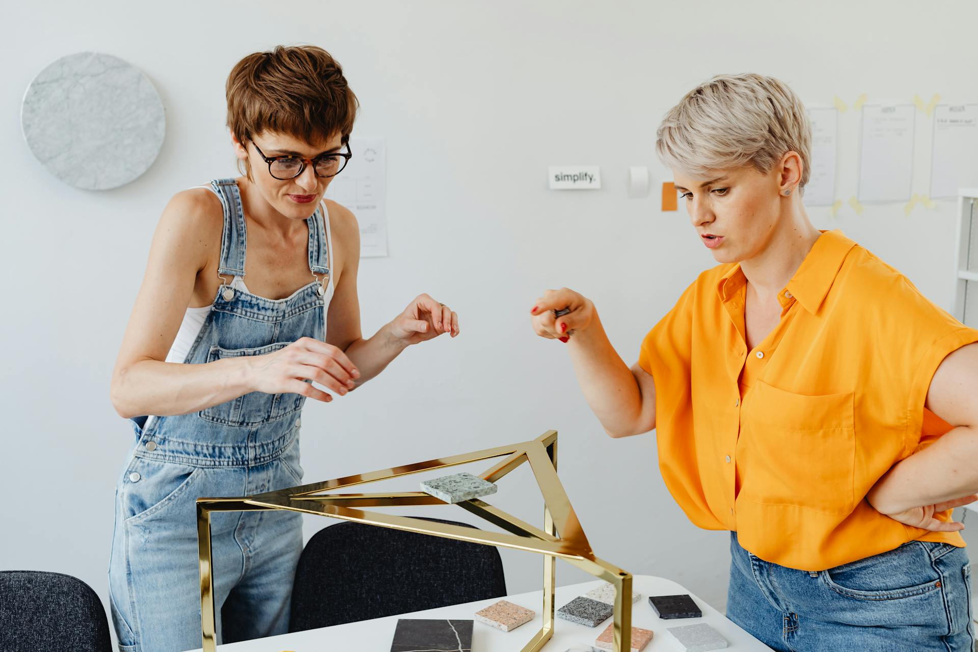 Two women collaborating on design indoors, showcasing creativity and teamwork in a modern workspace.