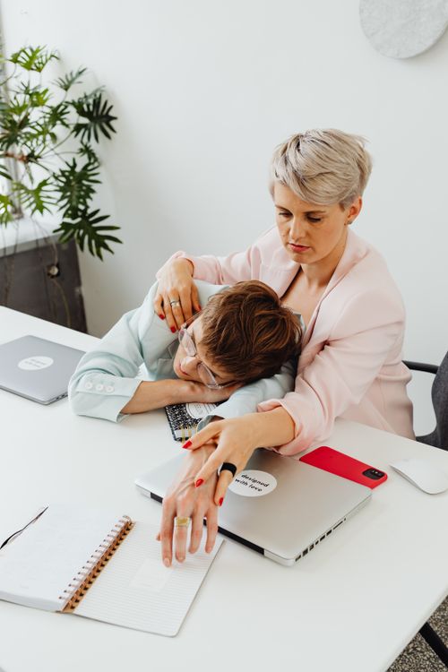 Free Lesbian couple working together at home office, embracing at a desk. Stock Photo