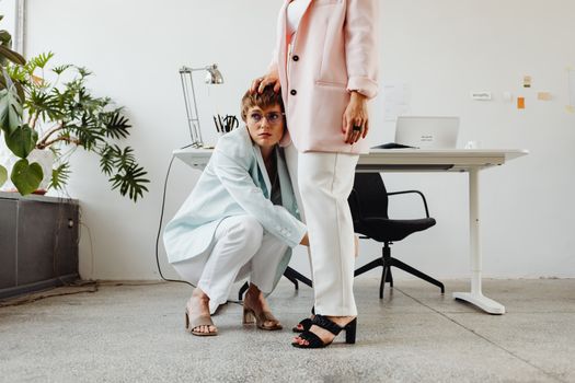 Stylish women in chic attire posing in a modern office environment.