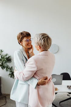 A loving couple in pastel suits showcasing affection in an indoor office setting.