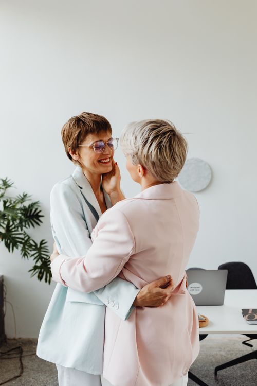 Free A loving couple in pastel suits showcasing affection in an indoor office setting. Stock Photo