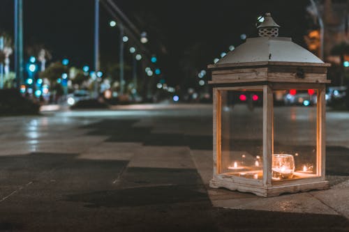 Free Selective Focus Photography of Glass Lantern with Lighted Candle on the Road Stock Photo
