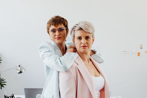 Free Portrait of two confident businesswomen in stylish corporate attire, embracing workplace diversity. Stock Photo