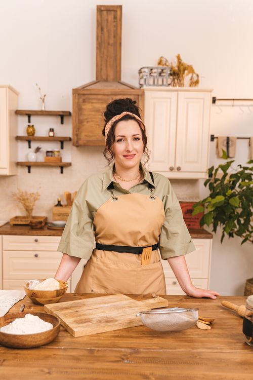 Free Chef in casual attire preparing ingredients in home kitchen setting with a warm atmosphere. Stock Photo