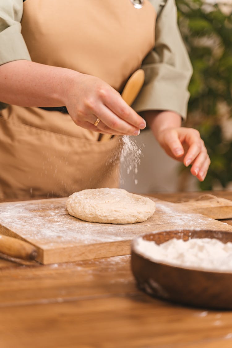 Person Adding Flour To A Dough