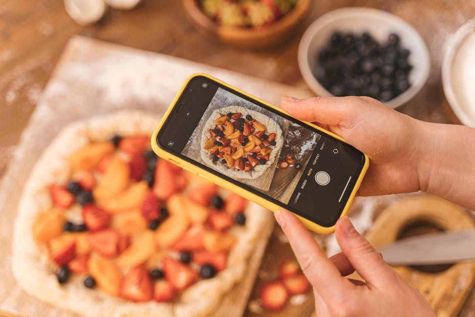 Tarte aux Fraises Rustique : La Recette Facile et Gourmande! 305 Person taking a photo of a homemade fruit pie with a smartphone.