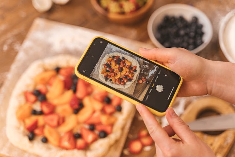 Person Taking A Picture Of A Fruit Pie 