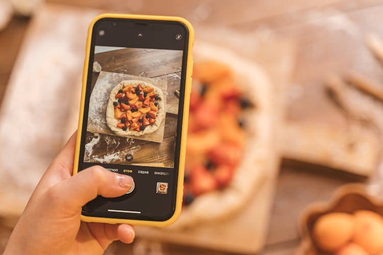 Person Taking Picture Of A Pie Using Smartphone