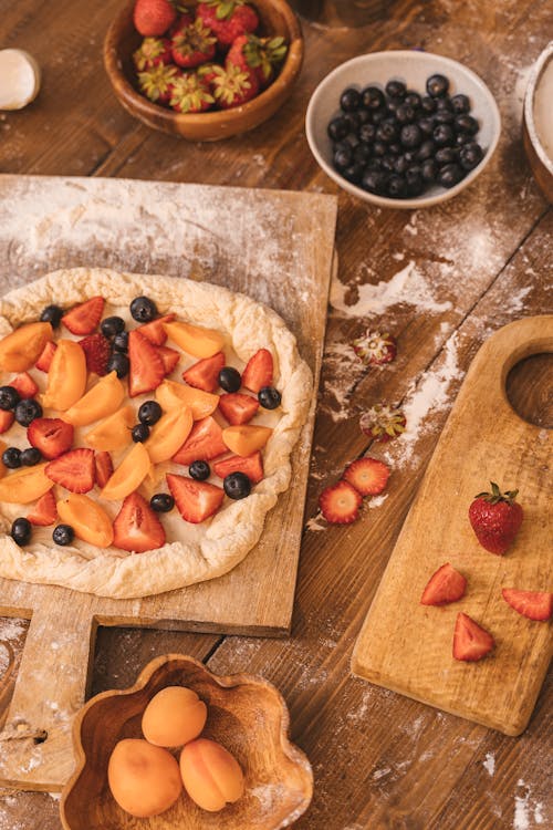 A Sliced Strawberries and Blueberries on a Dough