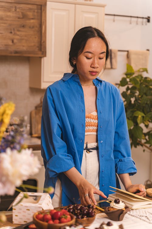 A Woman in Blue Long Sleeves  Standing in the Kitchen