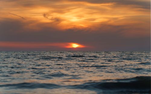 Free Beautiful ocean sunset with dramatic sky, capturing nature's vibrant colors and serene waves. Stock Photo