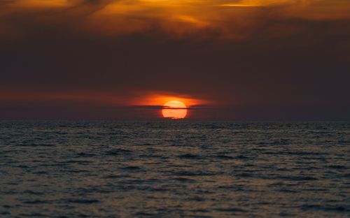 Free A breathtaking view of the ocean at sunset, featuring dramatic skies and golden hour lighting. Stock Photo