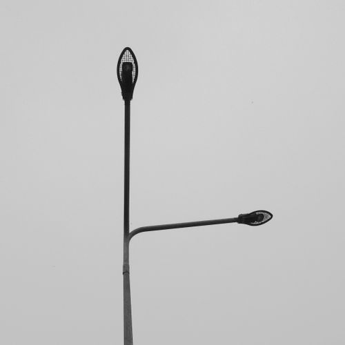 Free Minimalist photo of dual street lights against a gray sky in square format. Stock Photo