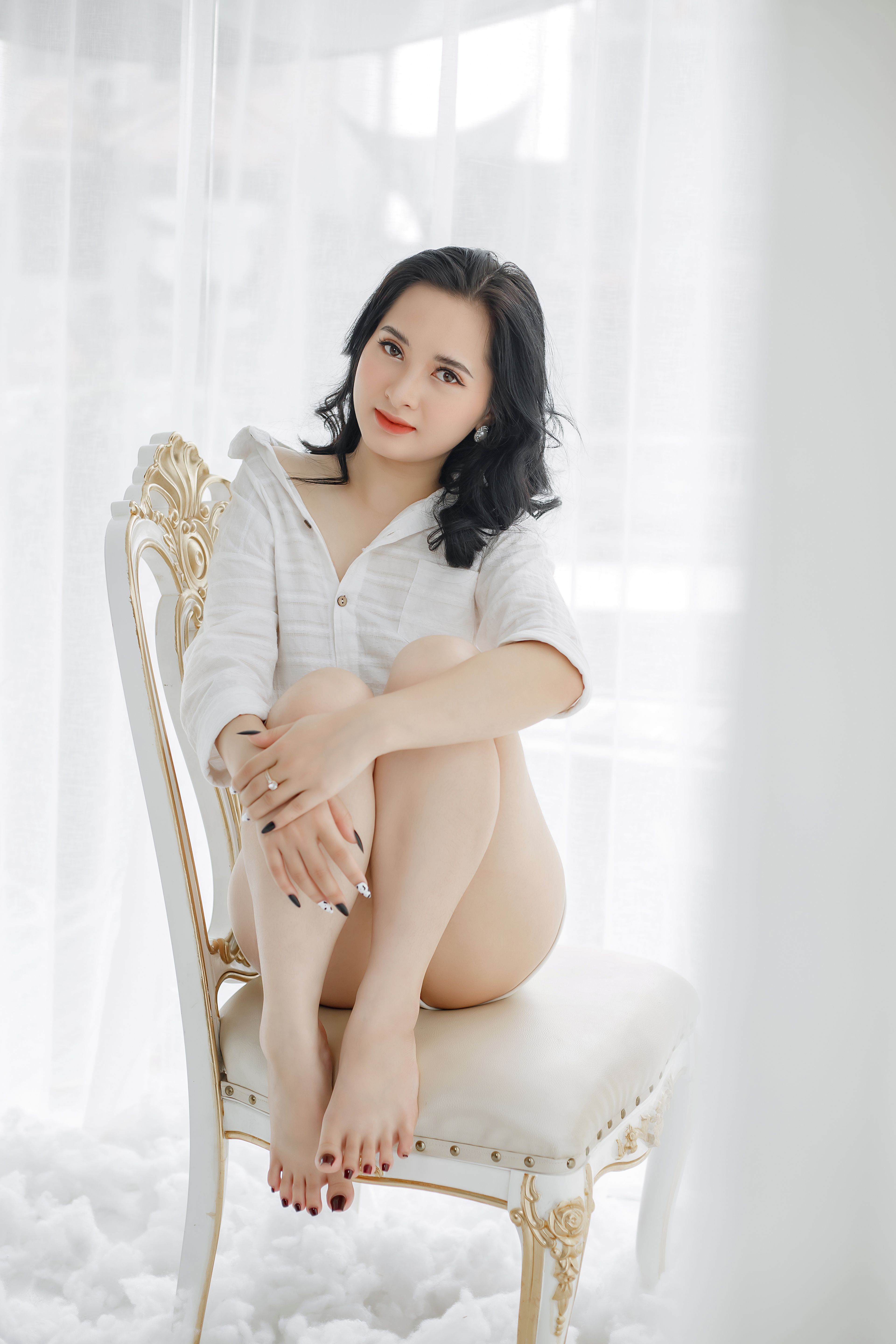 A Pretty Woman in White Long Sleeves Sitting on a Chair · Free Stock Photo