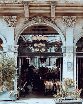 A beautifully arched entrance to a vintage-style restaurant, featuring intricate exterior design.