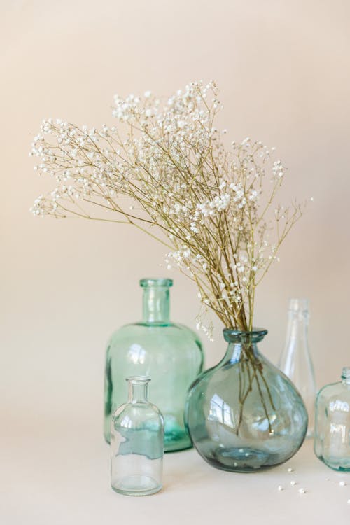 Бесплатное стоковое фото с бежевый фон, белые цветы, бутылки
