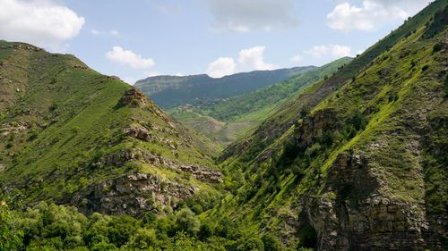 Free Scenic landscape of a green mountain valley under a clear blue sky. Stock Photo