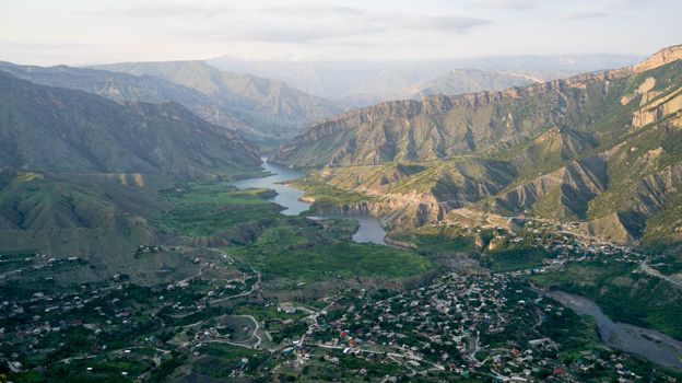 A breathtaking aerial view of a serene river winding through lush mountainous terrain.