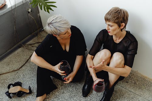 Free A Same Sex Couple Sitting on the Floor while Having Conversation Stock Photo