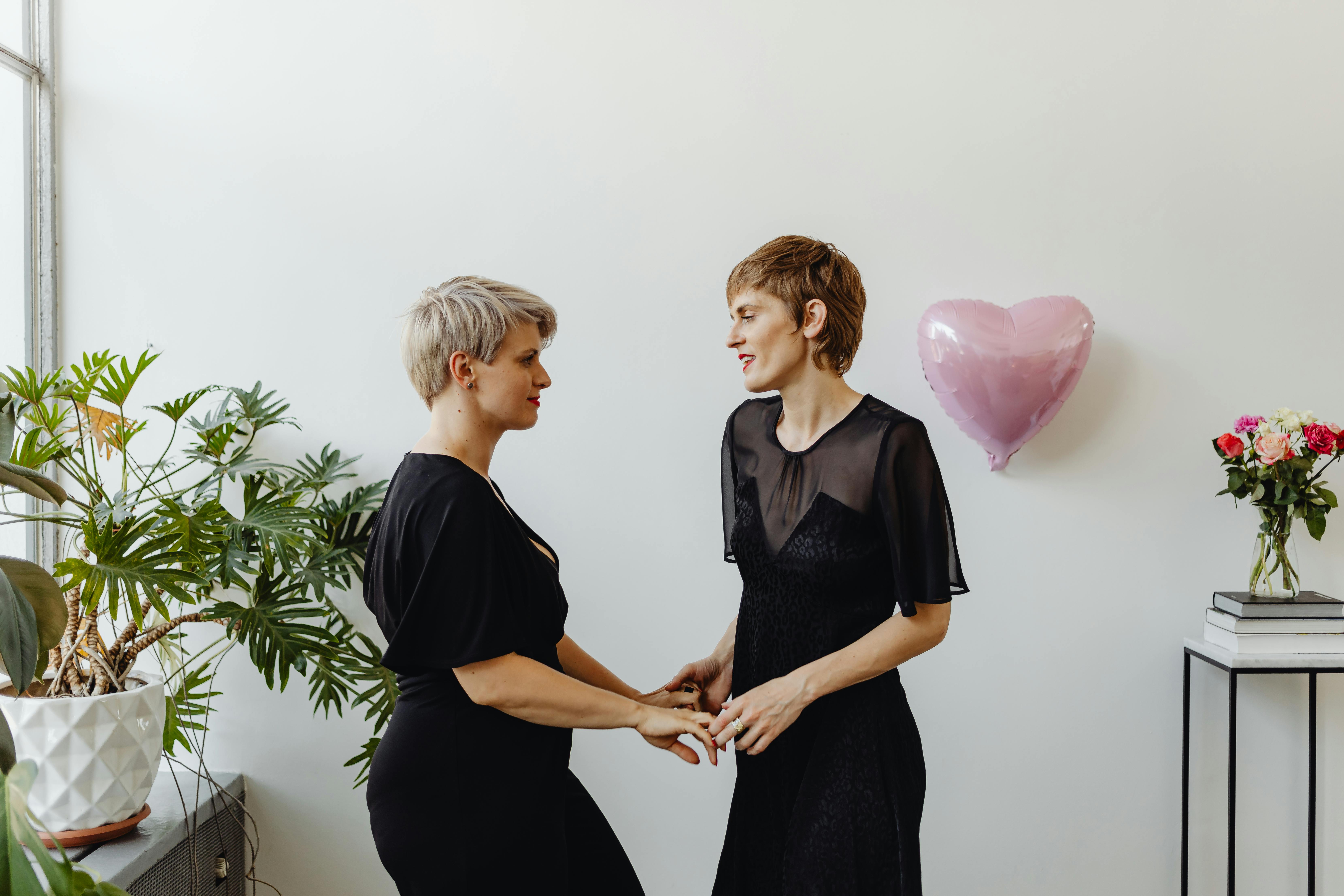 women wearing black dresses dancing together