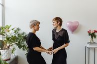 Woman in Black Dress Holding Pink Balloons