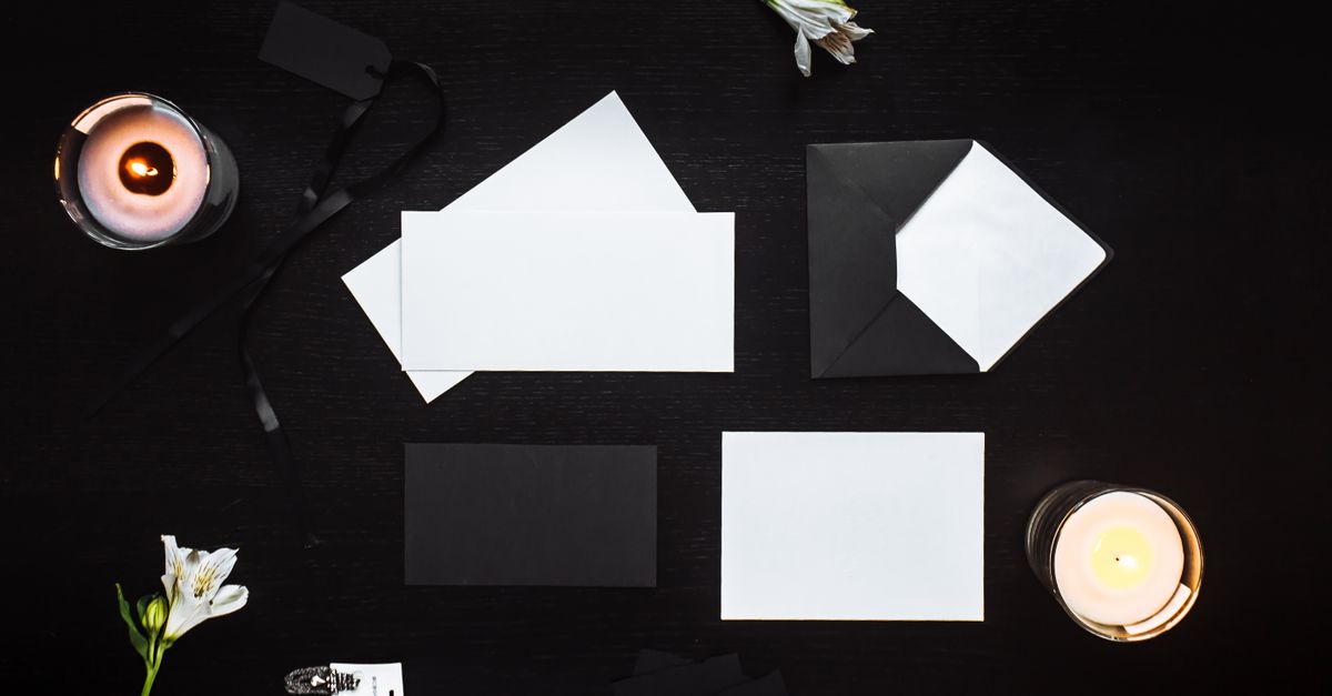 Top view of black and white envelopes with candles on a dark background. Perfect for design concepts.