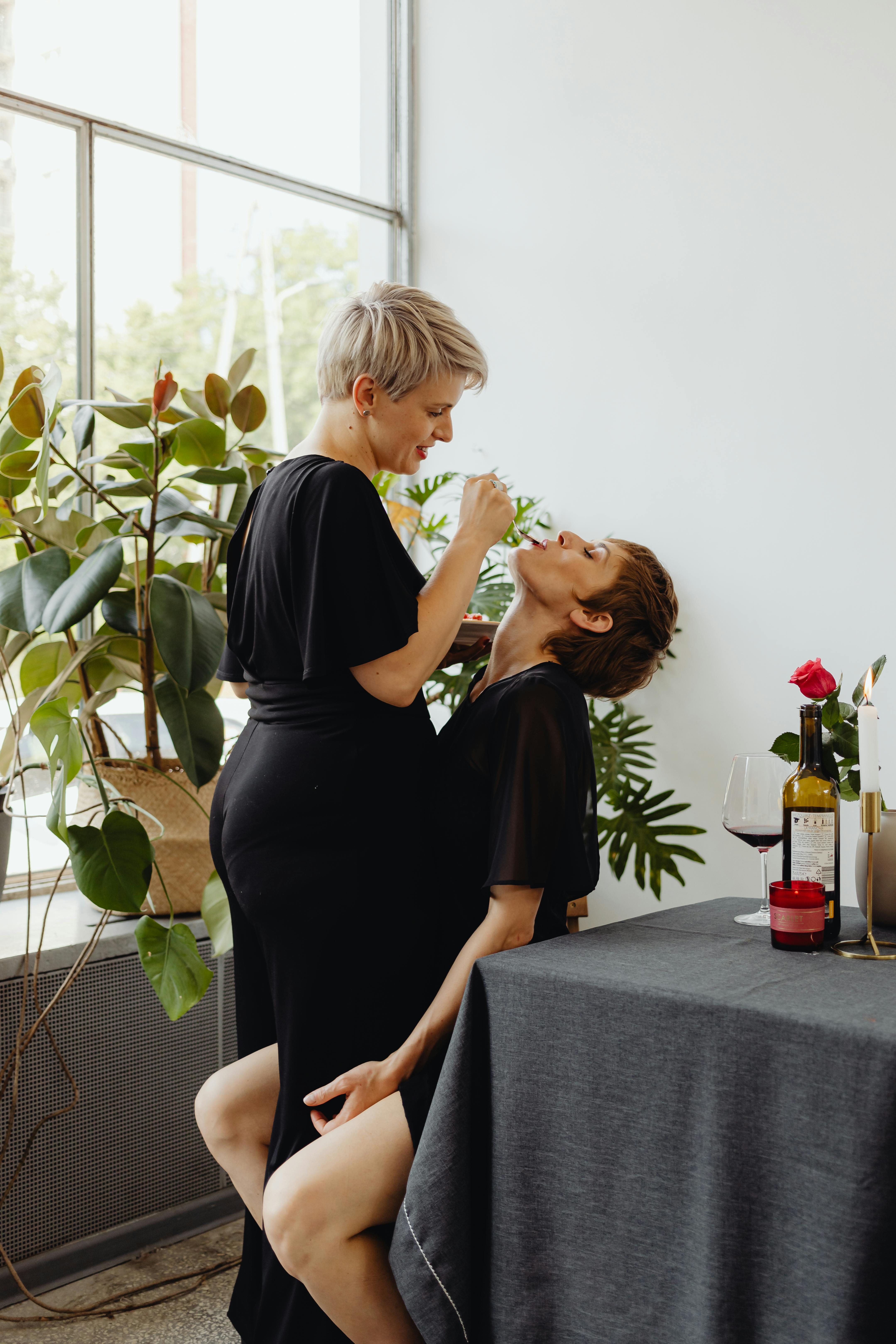 woman in black clothing feeding another woman