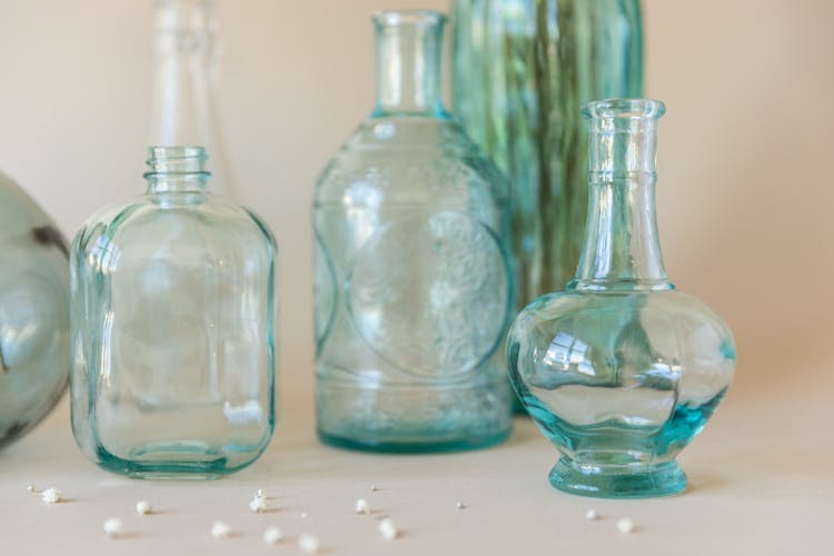 Clear Glass Bottles On White Surface