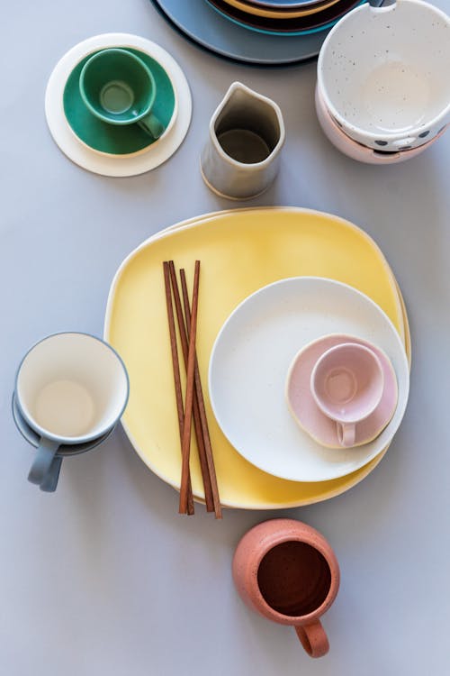 Ceramic Cups and Plates With Chopsticks on White Table