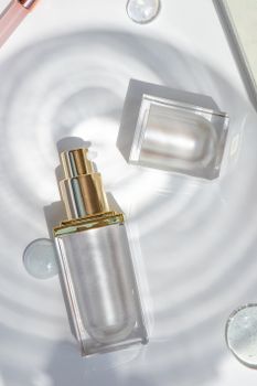 Minimalist still life of a transparent cosmetic spray bottle with reflections, captured in a bright studio.