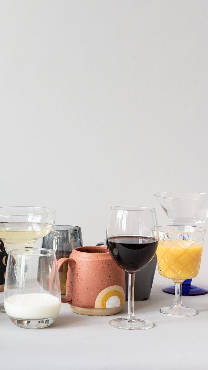 Colorful small ceramic mixing mug placed on a coffee bar hutch shelf