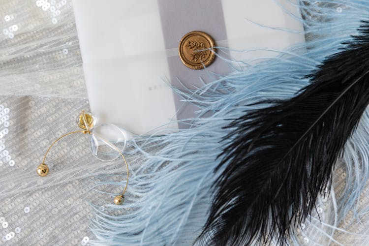 Feathers Besides A Sealed Invitation Card