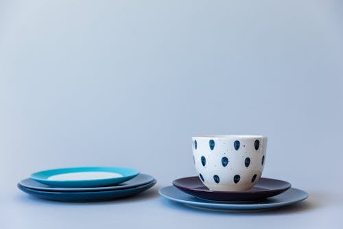 White and Blue Polka Dot Ceramic Cup on Blue Saucer