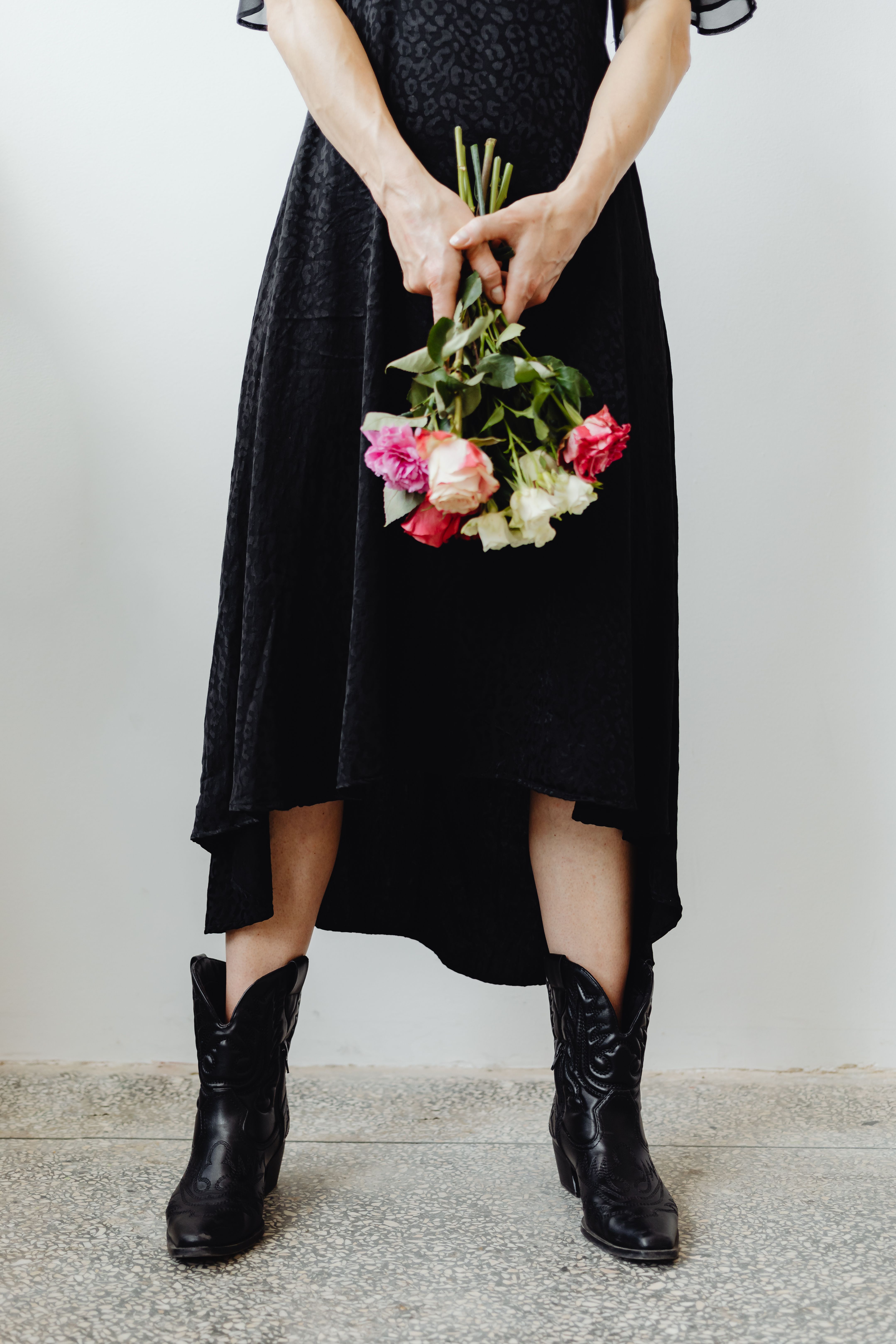 Woman in Black Dress Holding a Bunch of Roses  Free Stock Photo