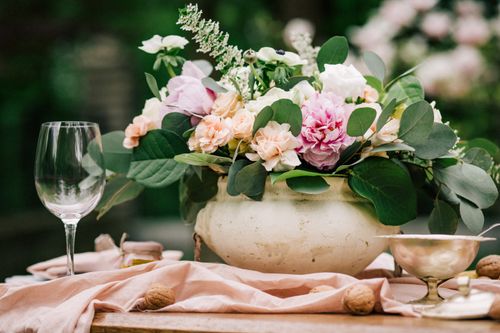 Free Beautiful table setting with a floral centerpiece and glassware in an outdoor garden Stock Photo