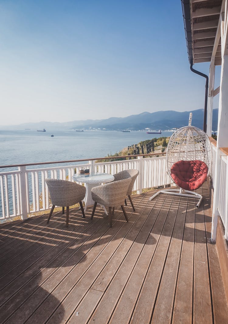 White Table And Brown Chairs On Brown Wooden Deck